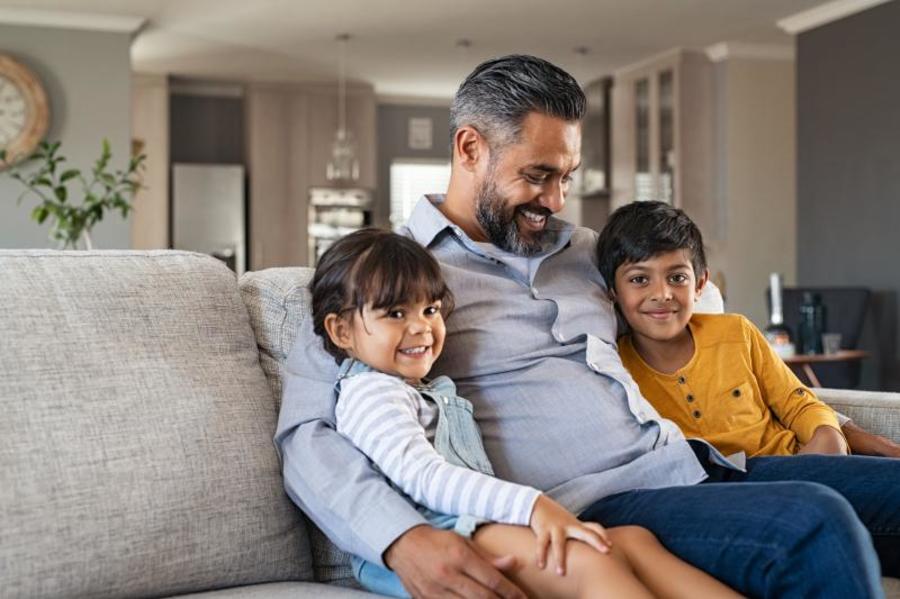 Father sitting with his two children on a couch.