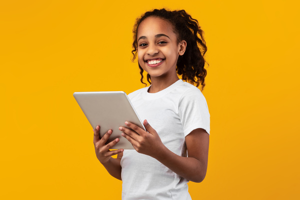Child holding a tablet.
