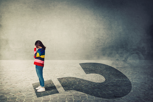 Person standing on the point of a question mark.
