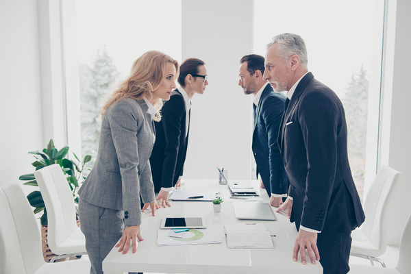 Group of colleagues facing each other with intense stares.