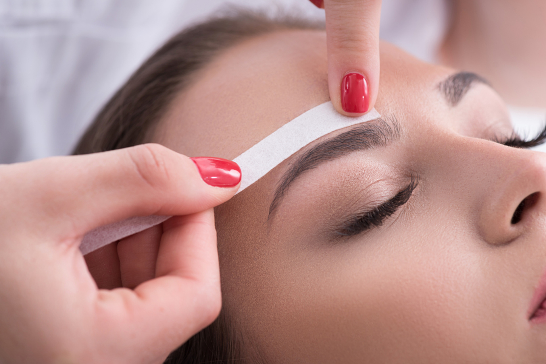 Woman having her eyebrow waxed. Woman having her eyebrow waxed.