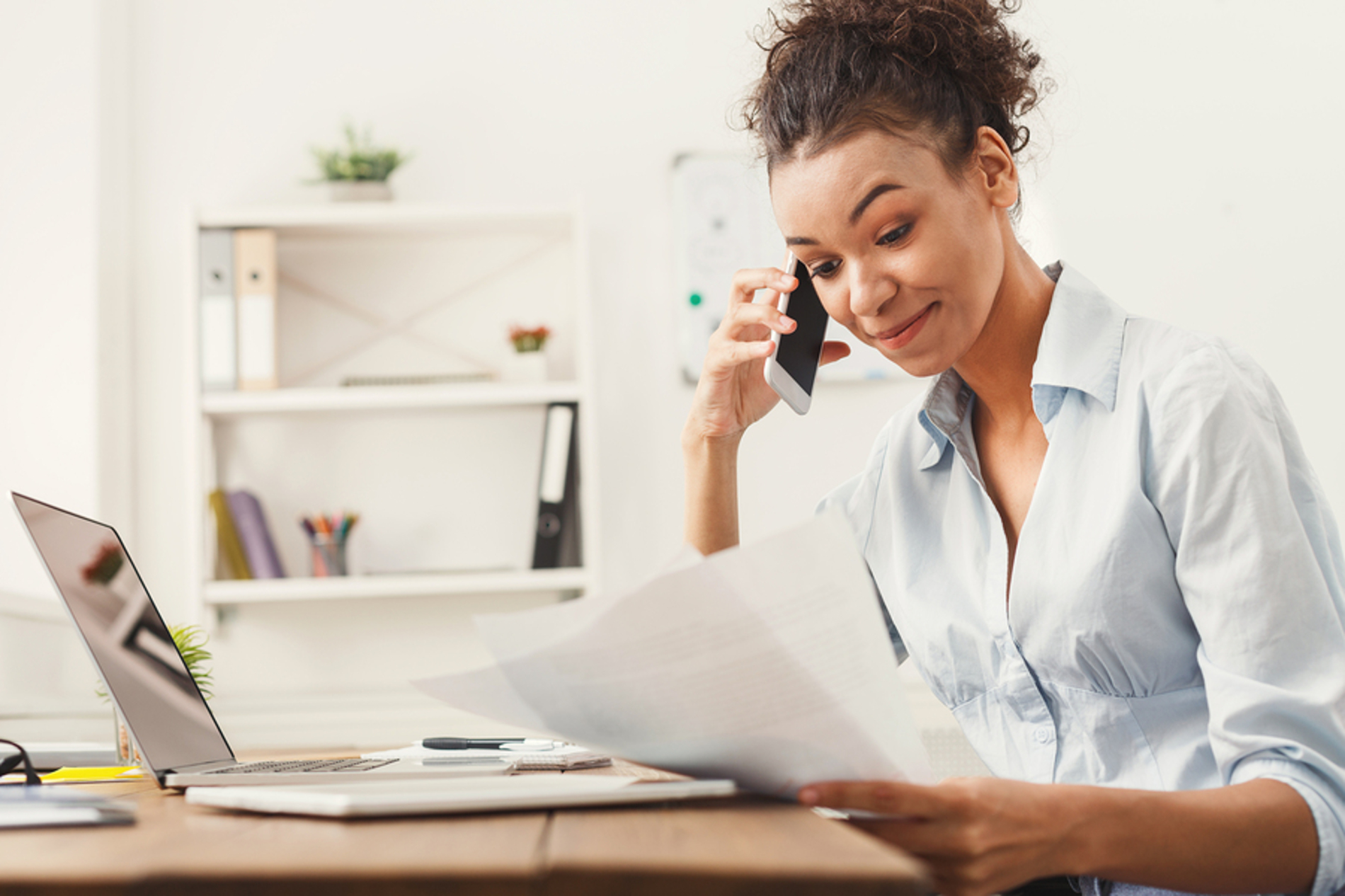 Woman on the phone looking at documents.