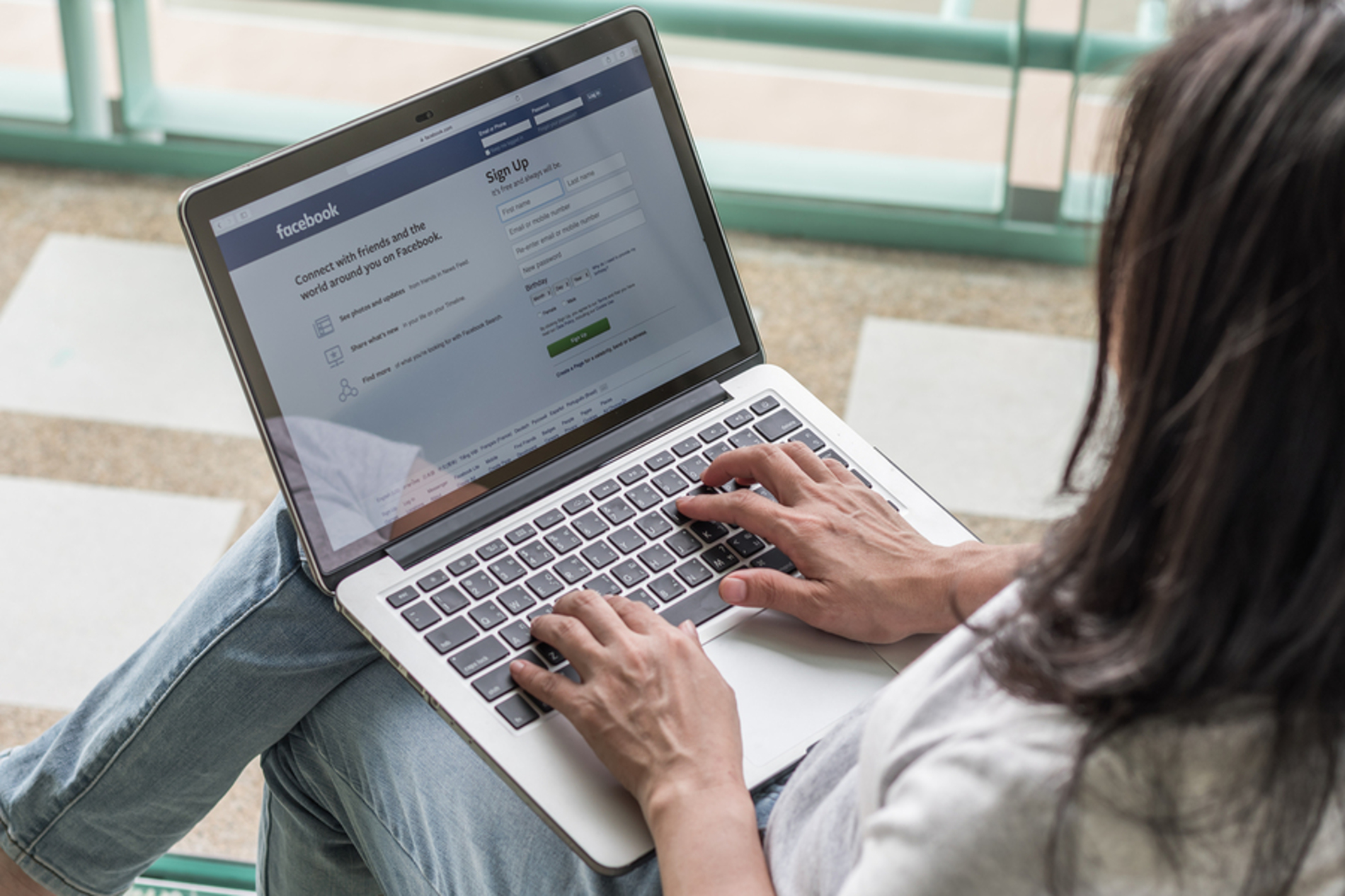 Woman accessing Facebook on her laptop computer.