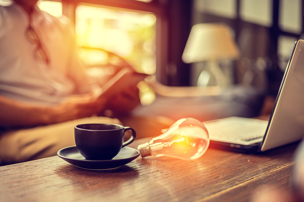 Cup of coffee and lightbulb on a table.