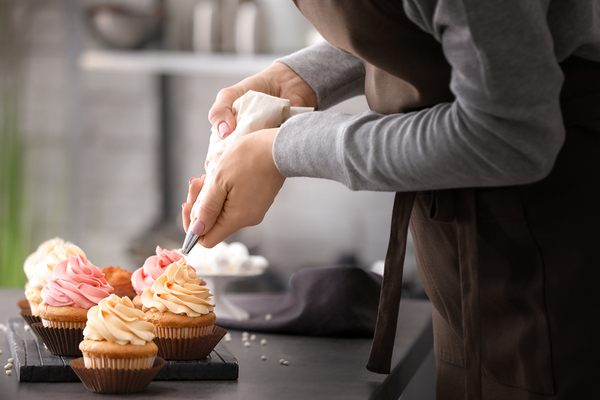 Woman decorating cupcakes.