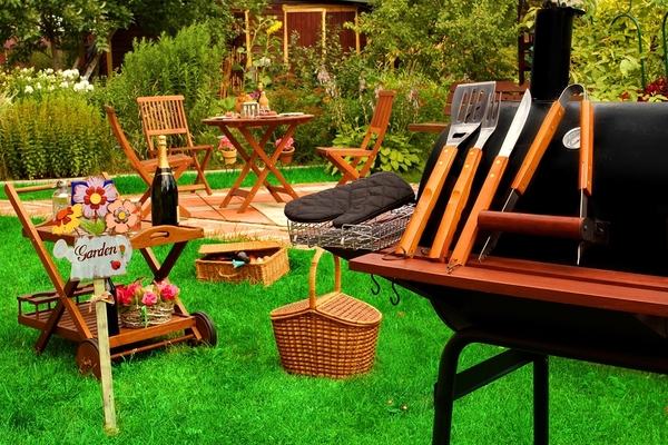 Outdoor barbecue with grille, and wooden seating.