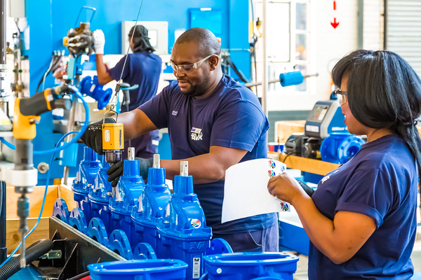 Workers in a factory smiling.