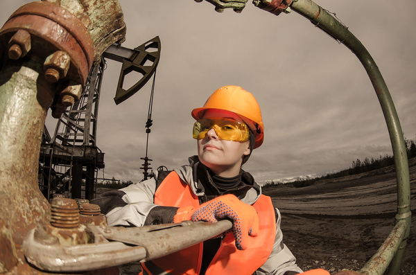 Female construction worker with orange hard hat and vest.