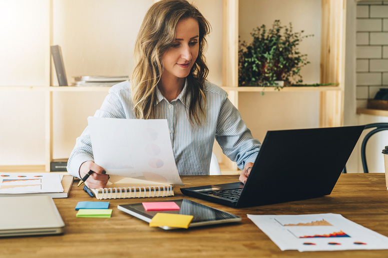 Woman working at a table with a laptop.