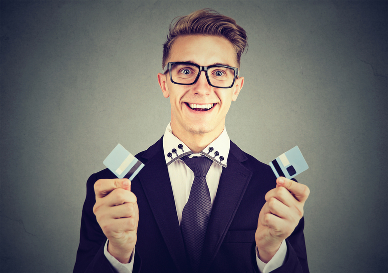 Man smiling with a cut up credit card.