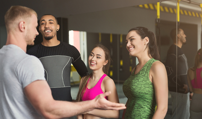 Happy group of young adults in a gym.