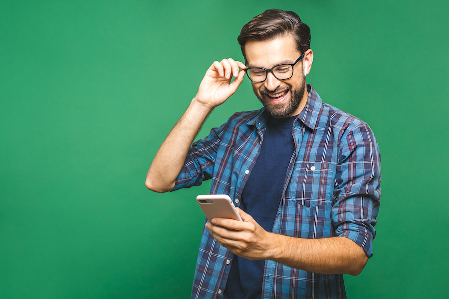Smiling man looking at his phone.