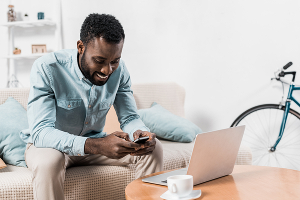 Man sitting on a couch using his phone.