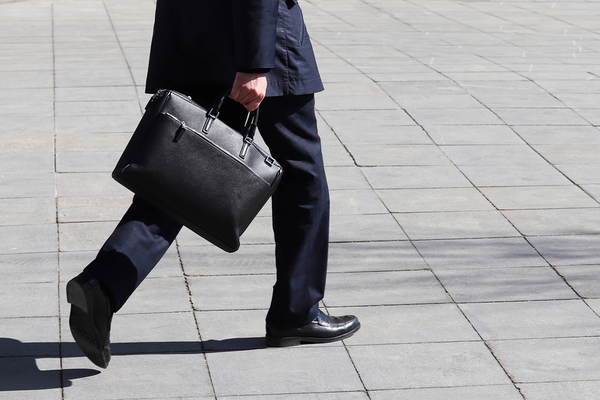 Man walking with a black leather briefcase.