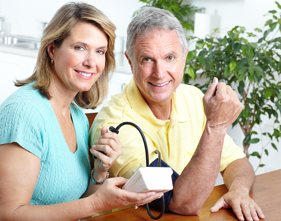 Woman taking a mans blood pressure.