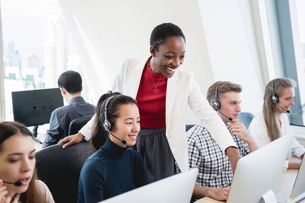 Group sitting at their desks with headsets.