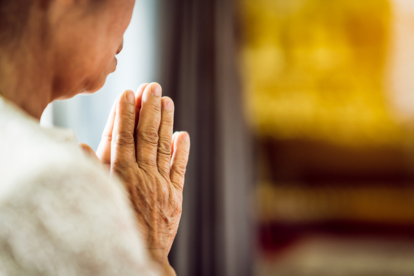 Woman holding her hands in prayer.