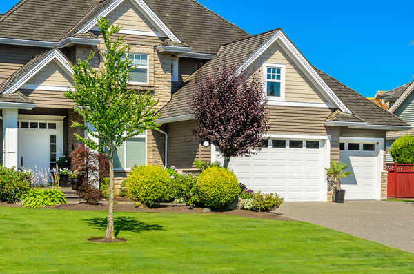 Tan colored home with brown roof and white trim.