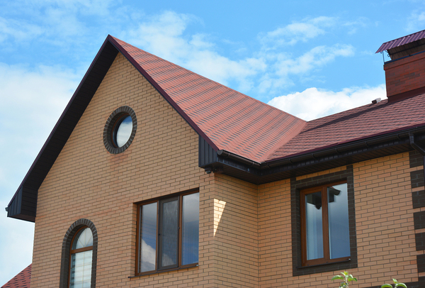 Brick front home with brown trim and gutters.