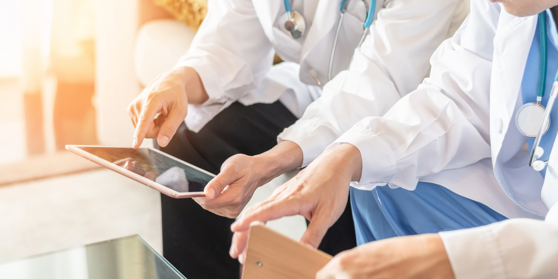 Medical doctors looking at tablets.