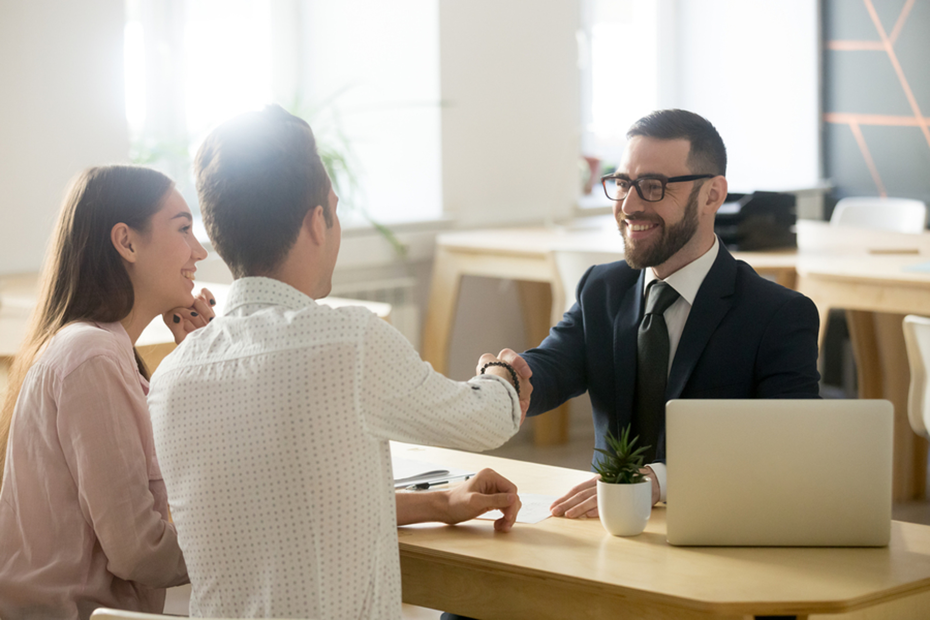 Couple shaking hands a businessman.