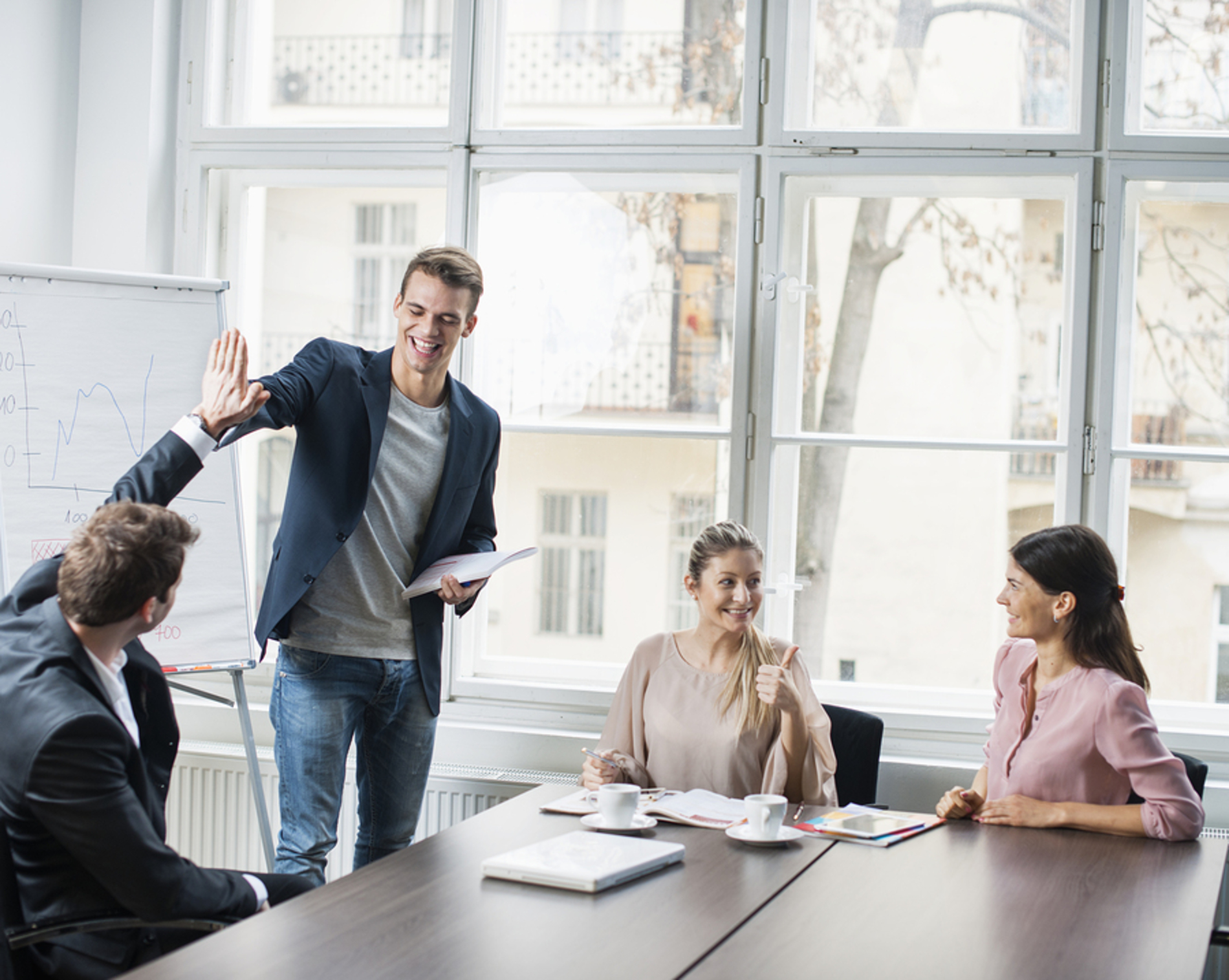 Group of coworkers discussing a project and giving "high five".