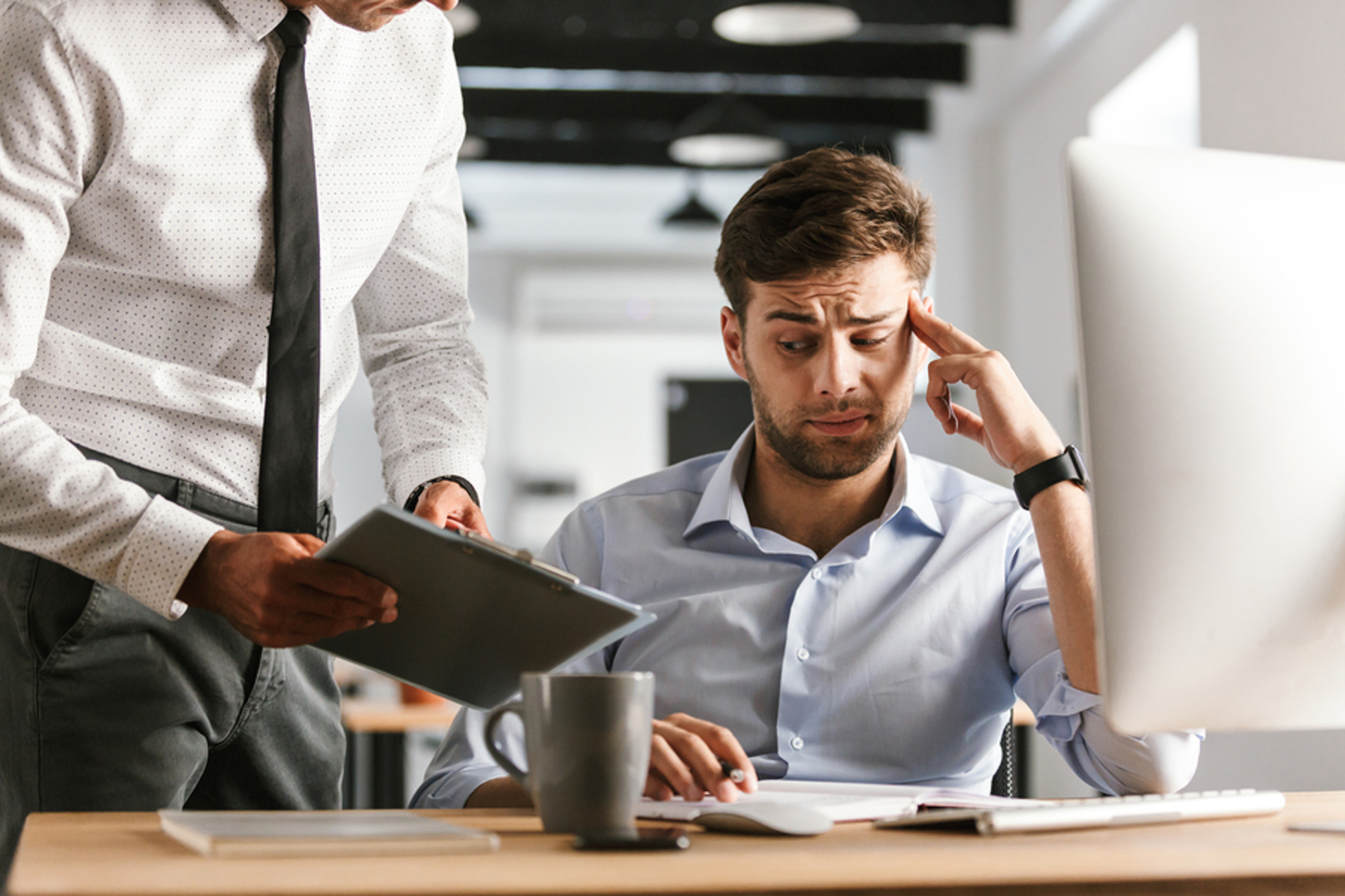 Two coworkers looking at a document together.