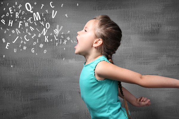 Young girl with white letters appearing to come out of her mouth.