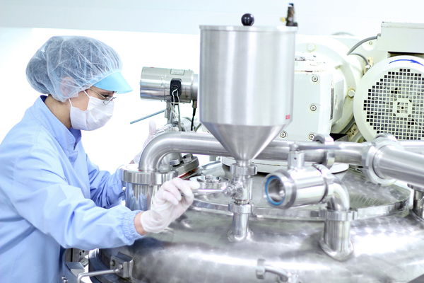 Worker with protective equipment fixing machinery.