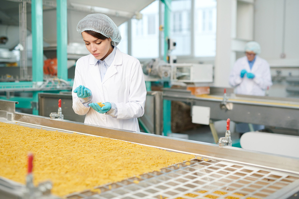Woman working in a factory inspecting product.
