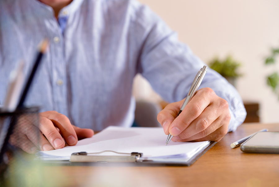 Medical doctor writing in a patient's chart.