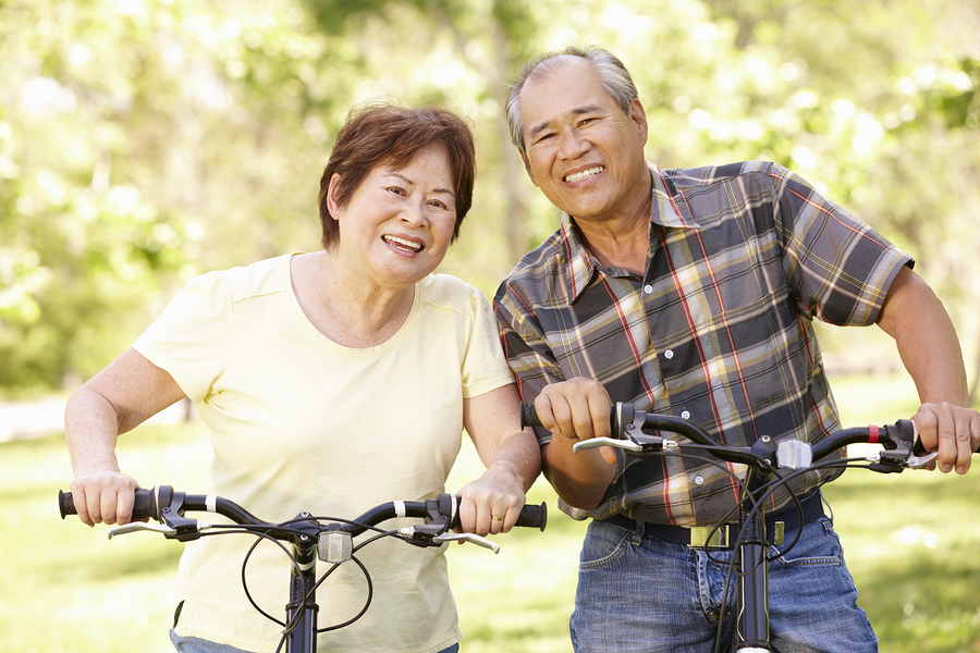 Smiling couple on bicycles.