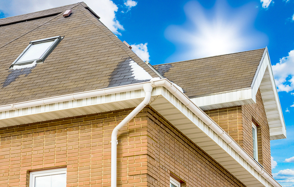 Brick home with white gutters and down spout.