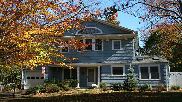 Blue house with white trim and white gutters.