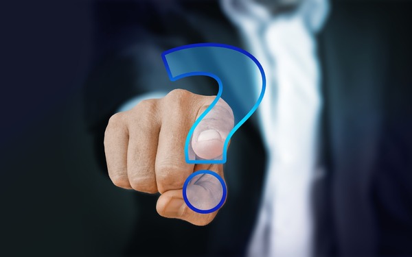 Person pointing to a digitally created question mark.