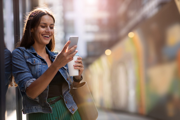 Woman smiling while using her phone. customer experience strategies