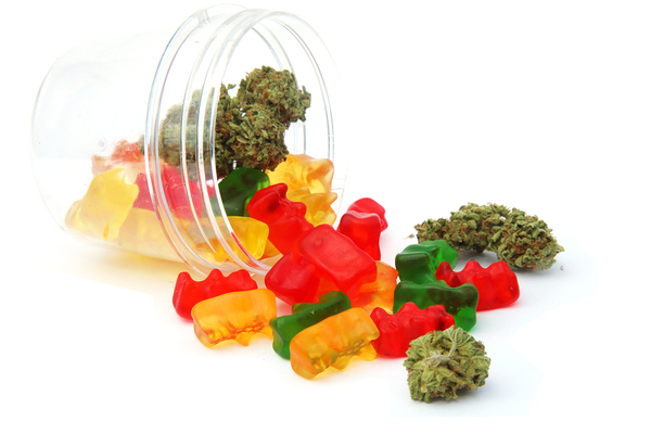 Cannabis candies and buds in a glass jar.