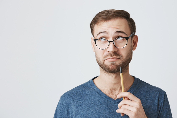 Man wearing glasses and holding a pencil.