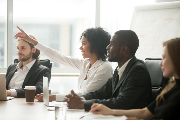 Group of people sitting at a conference table discussing a project.