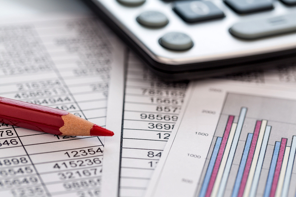 Calculator, pencil and documents with charts.