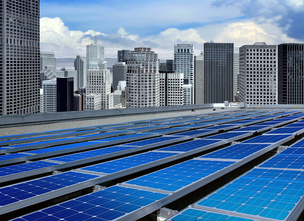 Solar panels in a city with sky scrapers in the background.