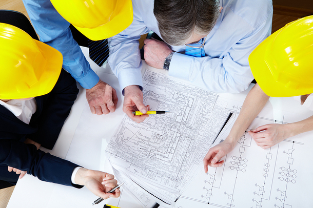 Group of architects looking at drawings.