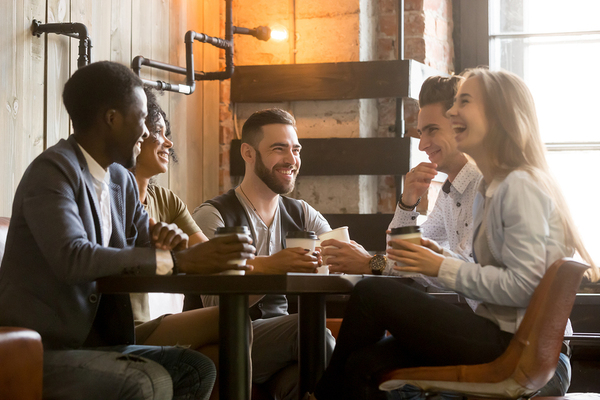 Group of people sitting around a table talking.