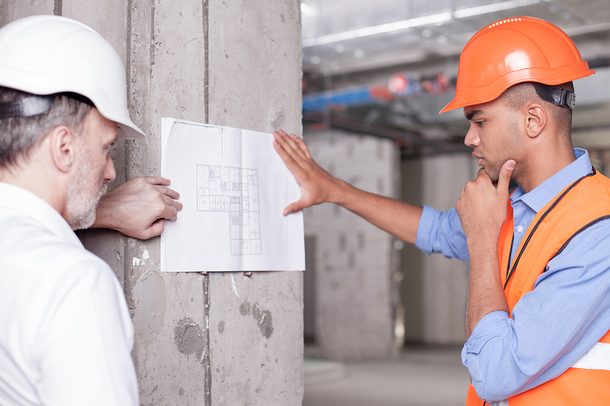 Two construction workers looking at building plans.