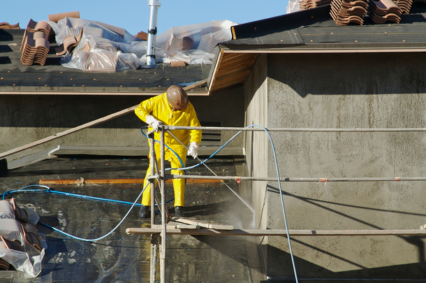 Construction worker on a support structure outside a building.