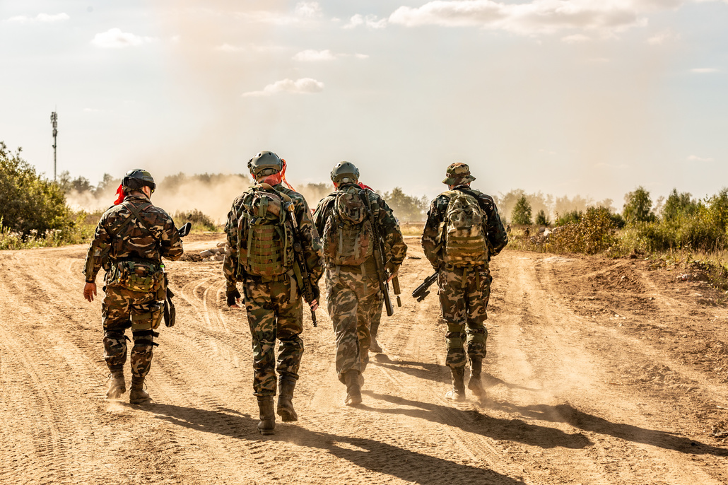 Solders walking down a dirt road.