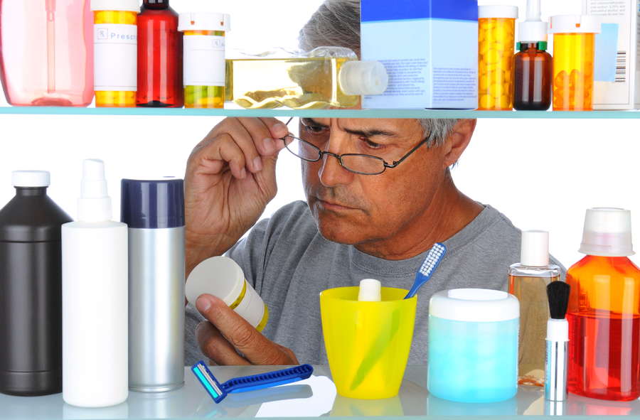 Man looking at a label on a pill bottle.