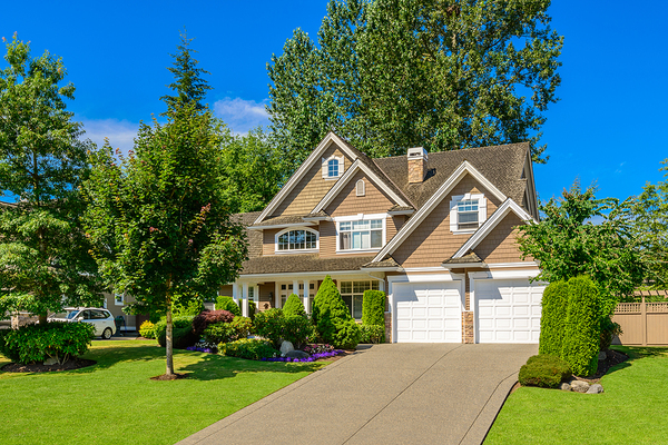 Tan colored home with white trim and gutters.