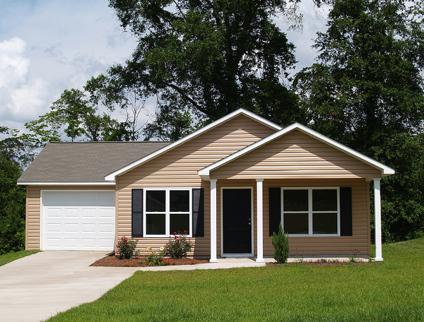 Tan colored home with white trim and single garage.
