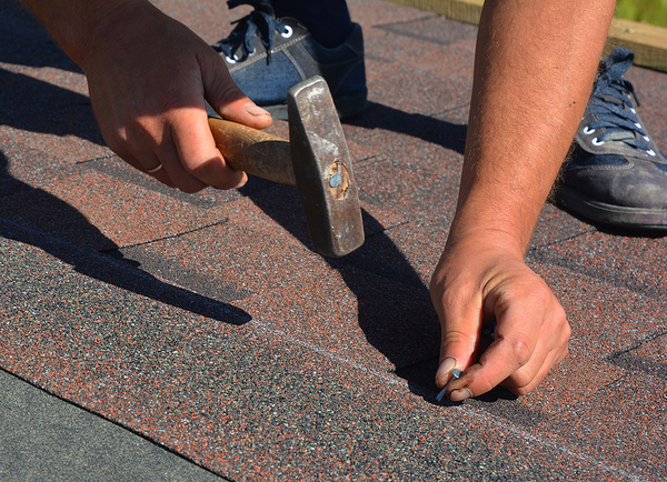 Nailing down roof shingles.
